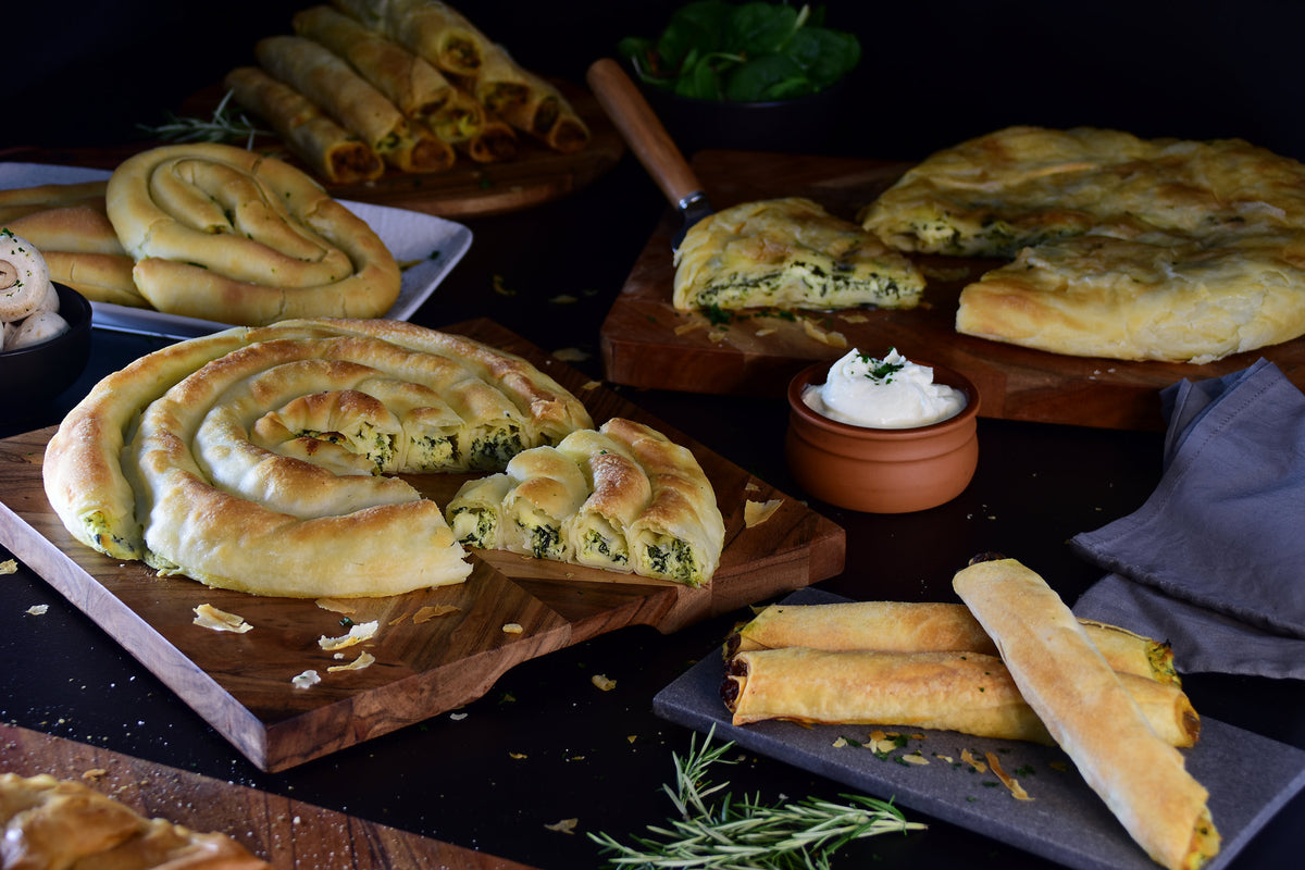 Burek, borek, spiral pastries and filo fingers served on wooden boards
